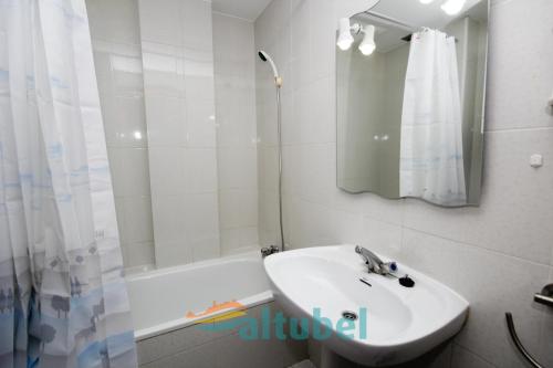a white bathroom with a sink and a shower at Edificio Esmeralda in Peniscola