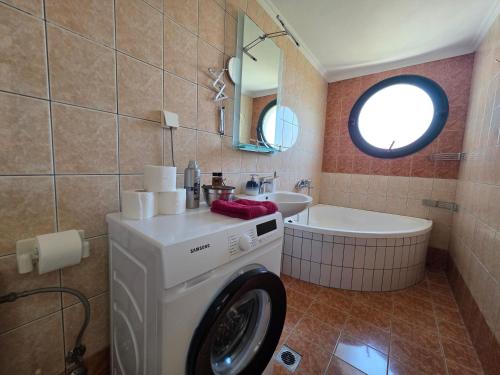 a bathroom with a washing machine and a sink at Alex House Garden in Iraklitsa