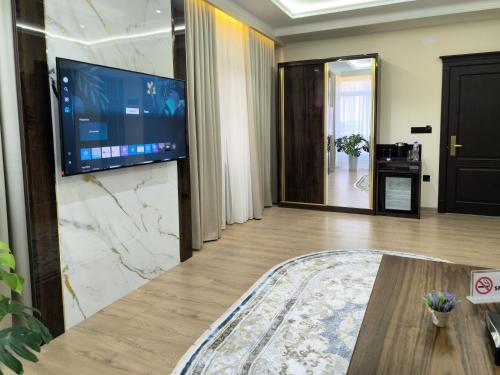 a living room with a large television on a wall at Анис in Khujand