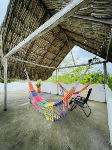 a hammock hanging from a roof on a patio at Casa Dibulla Hotel Boutique in Dibulla