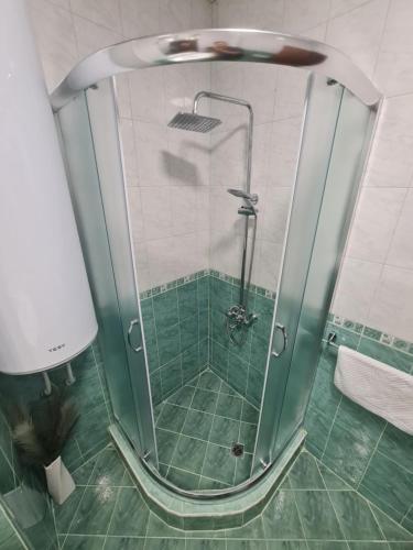 a shower with a glass door in a bathroom at Апартаменти Ванкови in Veliko Tŭrnovo