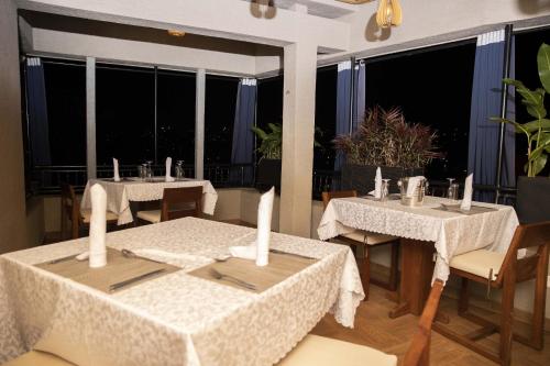 a restaurant with two tables and chairs and windows at Velvet Suites in Kigali