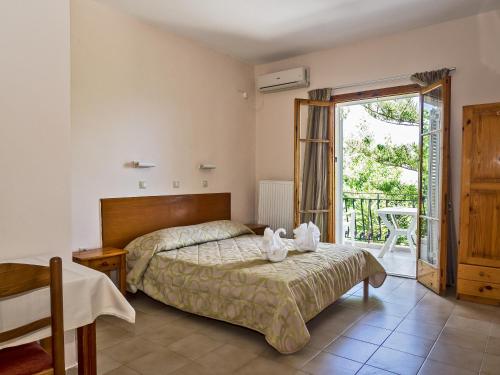 a bedroom with a bed and a sliding glass door at Sea Breeze Apartments in Lixouri