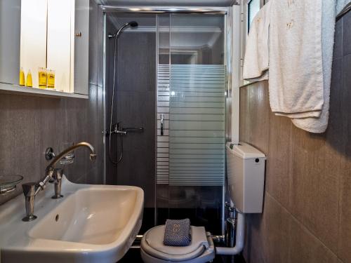 a bathroom with a sink and a toilet and a shower at Sea Breeze Apartments in Lixouri