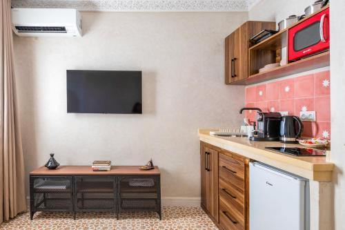 a small kitchen with a table and a tv at Studio JOSAFAT Medina Tanger in Tangier
