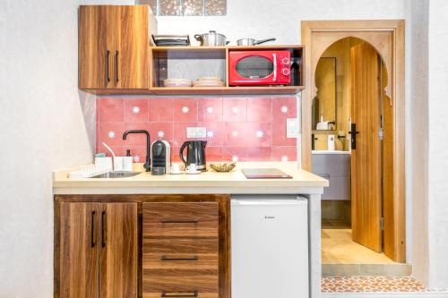 a small kitchen with a sink and a microwave at Studio JOSAFAT Medina Tanger in Tangier