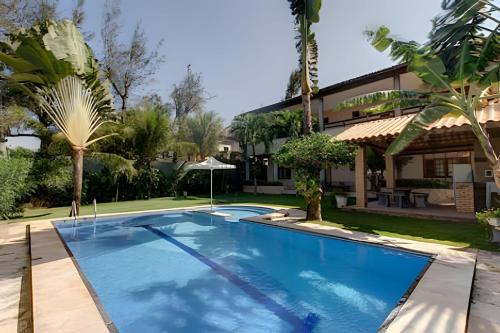 ein Swimmingpool vor einem Haus in der Unterkunft Mansão14Suítes-55Pessoas-BEACH PARK - HOUSINGCEARÁ in Aquiraz