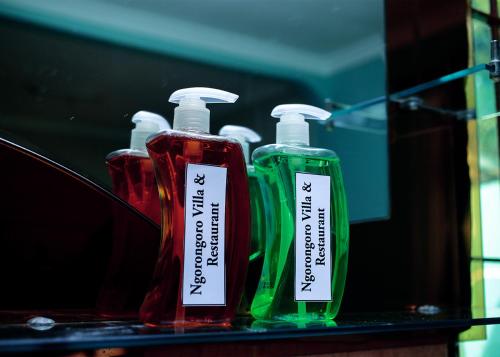 three bottles of detergent sitting on a shelf at Ngorongoro Villa and Restaurant in Karatu