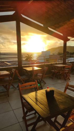 a table and chairs on a patio with a view of the ocean at Encanto da Praia hotel pousada in Natal