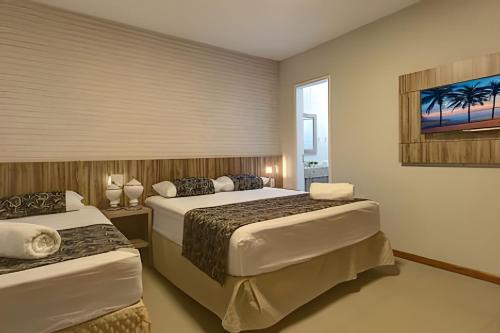 ein Hotelzimmer mit zwei Betten und einem Fenster in der Unterkunft Mansão Luxo 32 Pessoas-BeachPARK - BY HousingCeara in Aquiraz