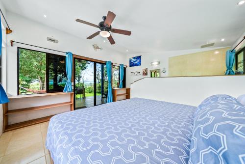 a bedroom with a bed and a ceiling fan at Sea View Modern dream House in Pavones