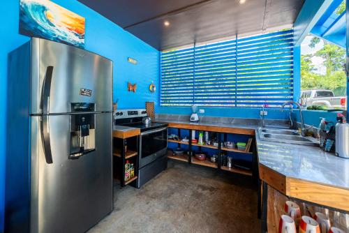 a kitchen with a stainless steel refrigerator and a sink at Sea View Modern dream House in Pavones