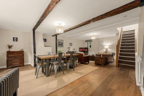 a dining room with a table and chairs and a living room at Stunning Bowdon Cottage by City SuperHost in Bowdon