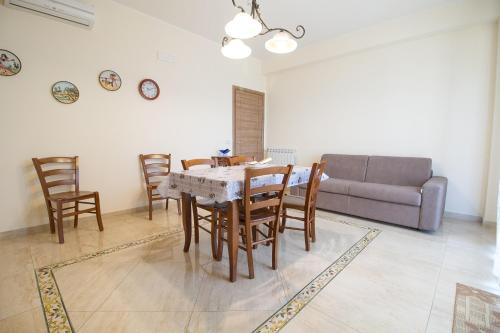 a living room with a table and chairs and a couch at Etna Royal View in Trecastagni