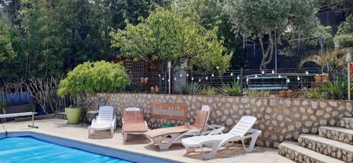 un groupe de chaises longues et une piscine dans l'établissement Appartement Climatisé T3 Piscine et Parking, à Pennautier