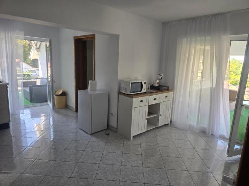 a kitchen with a microwave and a refrigerator at Ramhouse in Piteşti