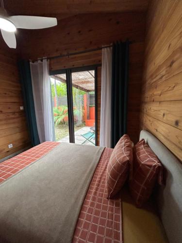 a bedroom with a bed and a large window at L'escapade du sud sauvage, la case in Saint-Joseph