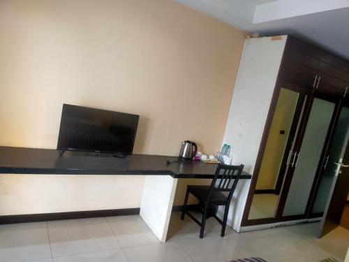 a desk with a laptop and a chair in a room at Moonlight Inn Room in Pattaya South