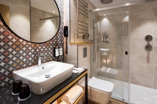a bathroom with a sink and a toilet and a mirror at Catalonia Excelsior in Valencia