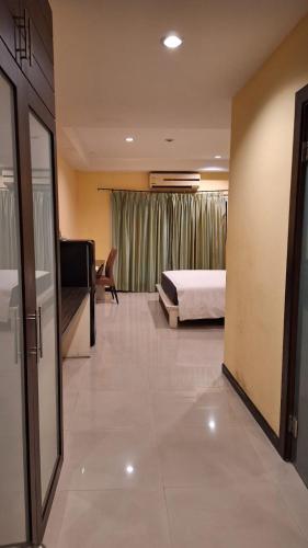 a bedroom with a bed and a room with a couch at Moonlight Inn Hotel Pattaya - Near Walking Street in Pattaya South