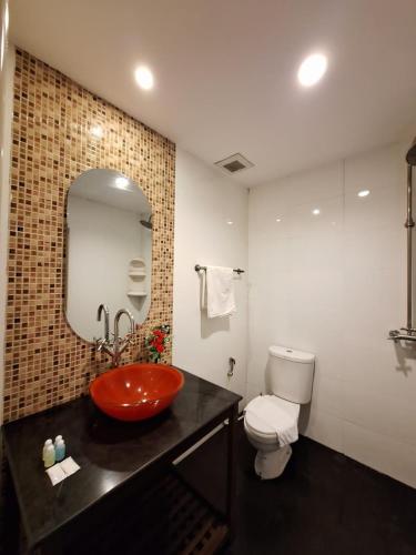 a bathroom with a red sink and a toilet at Moonlight Inn Hotel Pattaya - Near Walking Street in Pattaya South