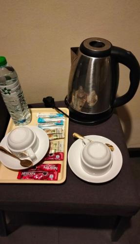 a table with two white plates and a tea kettle at Moonlight Inn Hotel Pattaya - Near Walking Street in Pattaya South