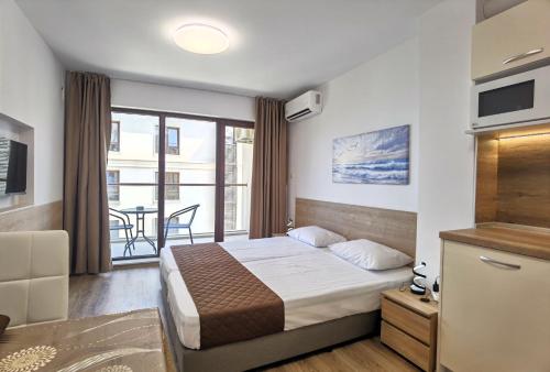 a hotel room with a bed and a balcony at Cabacum Pleasure Beachfront Apartments in Varna City
