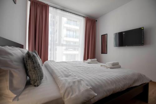 a bedroom with a bed with a large window at Luxe Pearl Towers in Bucharest