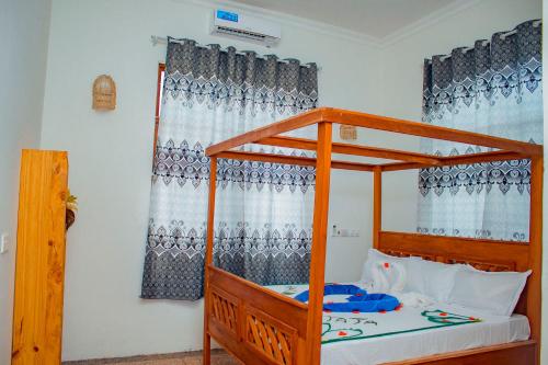 ein Schlafzimmer mit einem Etagenbett aus Holz mit blauen Vorhängen in der Unterkunft SG House in Paje