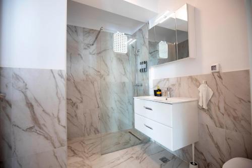 a bathroom with a white sink and a shower at Luxe Pearl Towers in Bucharest