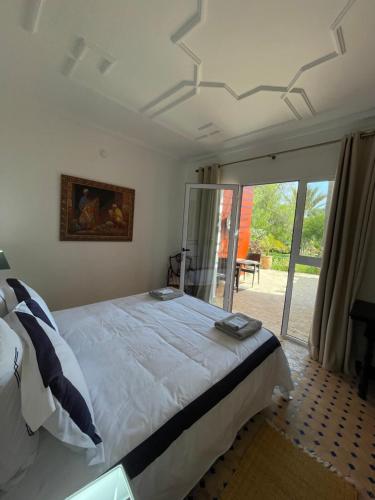 a bedroom with a large bed and a large window at Domaine des Mimosas in Essaouira