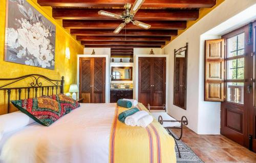 a bedroom with a large bed and a ceiling fan at Can Andreuet in Sant Carles de Peralta