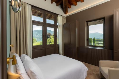 ein Schlafzimmer mit einem Bett und einem großen Fenster in der Unterkunft Baluardo Boutique Apartments in Clusane sul Lago