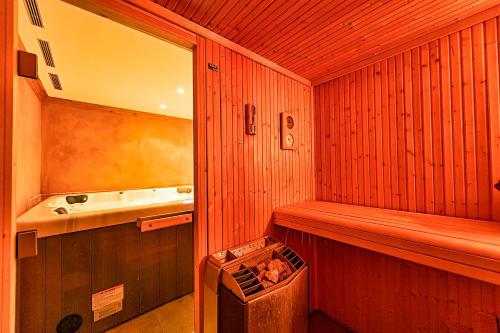 a small bathroom with a tub and a sink at Le Cervin Rouge in Crans-Montana