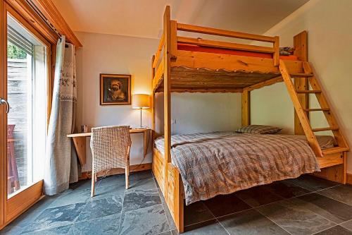 a bedroom with a bunk bed and a desk at Le Cervin Rouge in Crans-Montana
