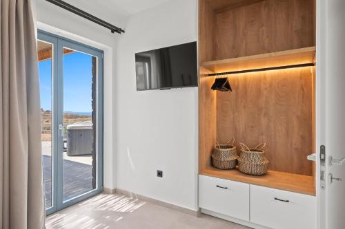 a kitchen with white cabinets and a sliding glass door at Coastal Retreat Naxos in Naxos Chora