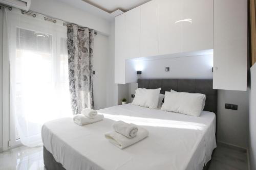 テッサロニキにあるIoannaApartments LuxuryPenthouseのタオルが敷かれた白い部屋にベッドが2つある