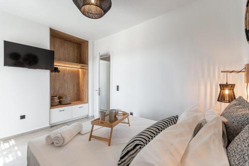 a white room with a bed and a table at Coastal Retreat Naxos in Naxos Chora