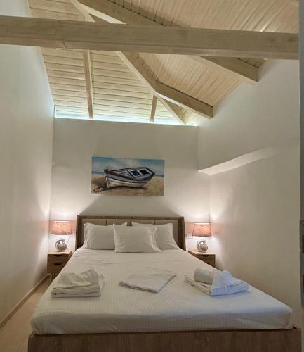 a bedroom with a bed with a painting on the wall at WoodHome in Kalamitsi