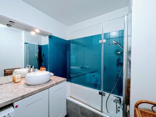 une salle de bain avec un lavabo et une douche en verre dans l'établissement Chic and spacious apart with parking and garden, à Saint-Denis
