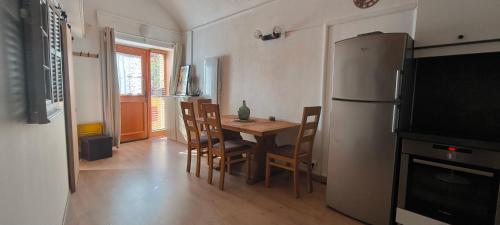 une cuisine avec une table avec des chaises et un réfrigérateur dans l'établissement Logette à Ezio, zone piétonne, à Menton