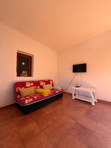 a living room with a red couch and a tv at Nature in Tejeda in Tejeda