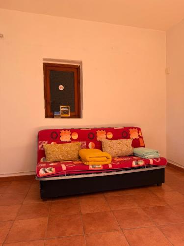 a red couch in the corner of a room at Nature in Tejeda in Tejeda