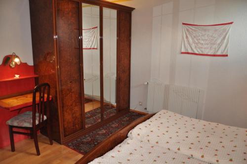 a bedroom with a wooden cabinet next to a bed at Almen-Kräuter-Oberreiter in Dellach im Drautal