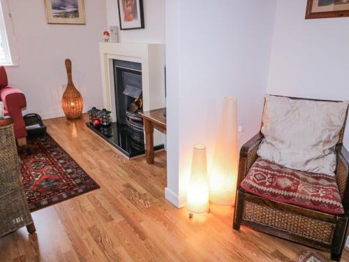 a living room with a fireplace and a chair and a lamp at The Burma in Letterkenny