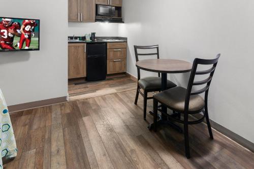 a kitchen with a table and chairs in a room at HomeTowne Studios & Suites by Red Roof Charlotte - Ballantyne in Charlotte