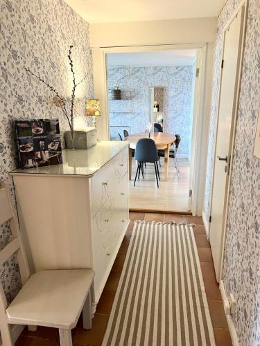 a kitchen with a table and a dining room at Beautiful rooms in a charming Båstad villa top location near the beach and town center in Båstad