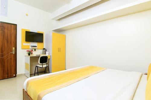 a bedroom with a bed and a desk and a tv at HOTEL O JMD INN in Gomti Nagar