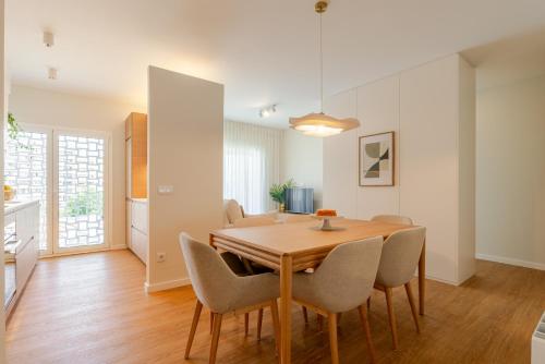 a dining room with a wooden table and chairs at Stylish & Spacious Apartment by HostWise in Porto