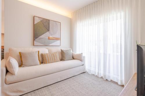 a living room with a white couch in front of a window at Stylish & Spacious Apartment by HostWise in Porto